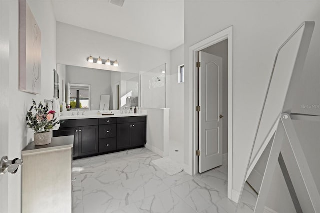 full bathroom featuring double vanity, marble finish floor, a sink, and a stall shower