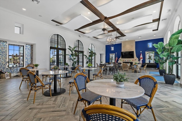 dining space featuring baseboards, a towering ceiling, ornamental molding, a notable chandelier, and recessed lighting