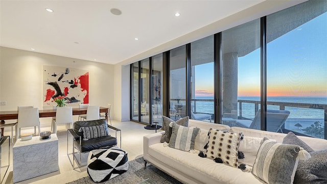 living area featuring a wall of windows, recessed lighting, and a water view