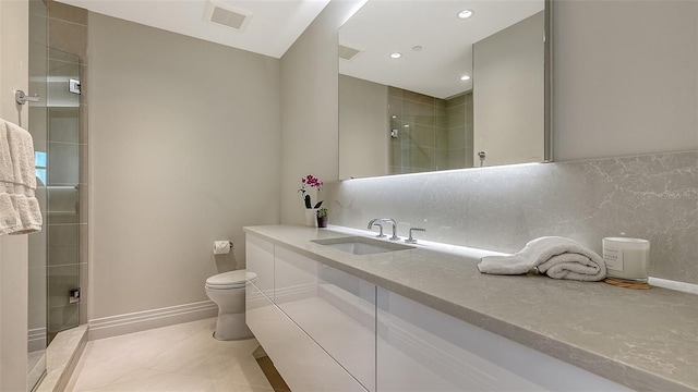 bathroom featuring visible vents, toilet, a tile shower, vanity, and tile patterned flooring