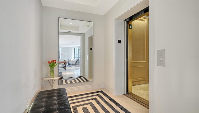 hallway featuring elevator and baseboards