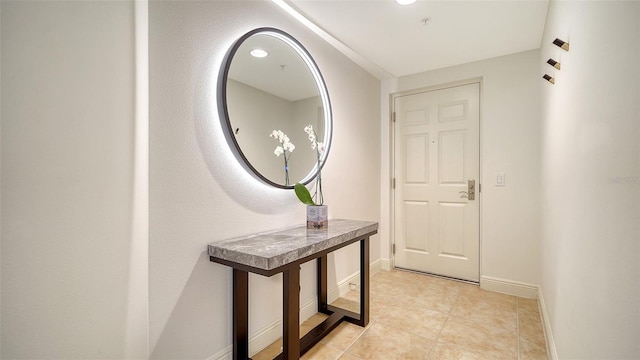 interior space with baseboards and light tile patterned flooring