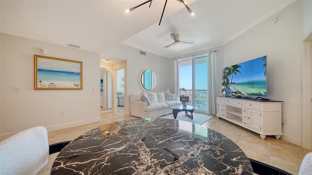 living room featuring arched walkways, visible vents, baseboards, and ornamental molding