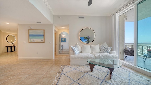 living room featuring visible vents, arched walkways, crown molding, light tile patterned floors, and baseboards