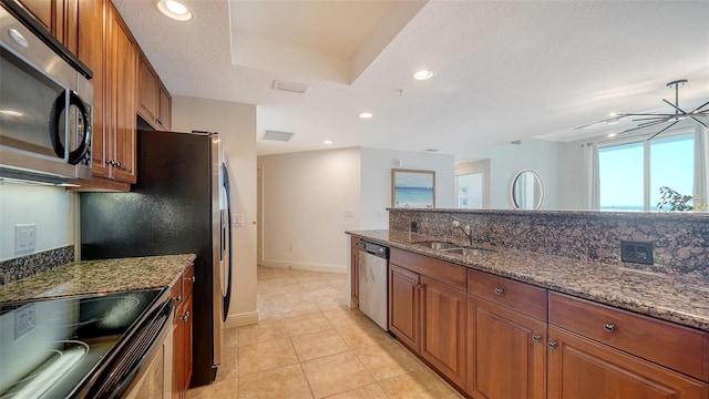 kitchen with a sink, decorative backsplash, appliances with stainless steel finishes, and brown cabinetry