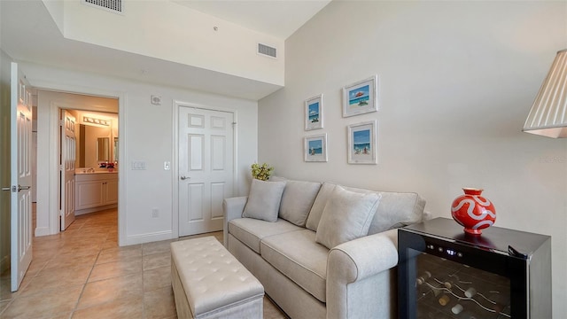 living area featuring light tile patterned floors, visible vents, and baseboards