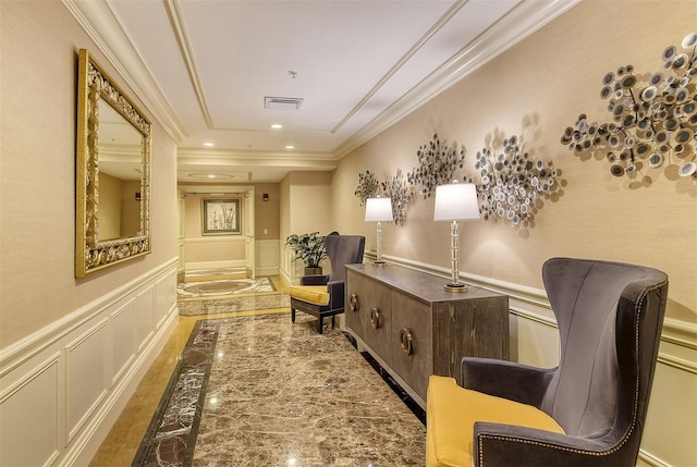 hallway featuring visible vents, crown molding, recessed lighting, wainscoting, and a decorative wall