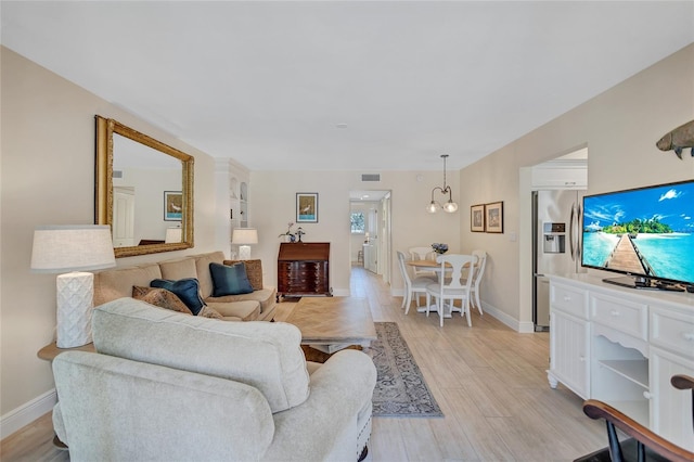 living area with light wood finished floors, baseboards, and visible vents