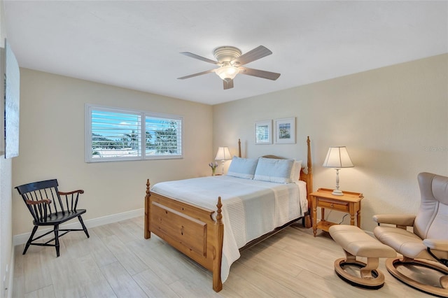 bedroom with light wood-style floors, ceiling fan, and baseboards