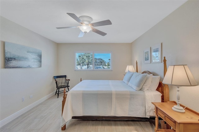 bedroom with light wood-type flooring, baseboards, and a ceiling fan