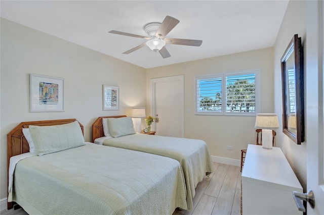 bedroom with ceiling fan, light wood finished floors, and baseboards