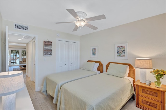 bedroom featuring visible vents, baseboards, a ceiling fan, light wood-style flooring, and a closet