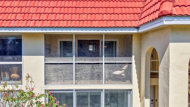 view of property exterior with a tile roof and stucco siding