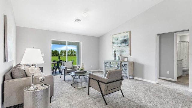 carpeted living area with visible vents, vaulted ceiling, and baseboards