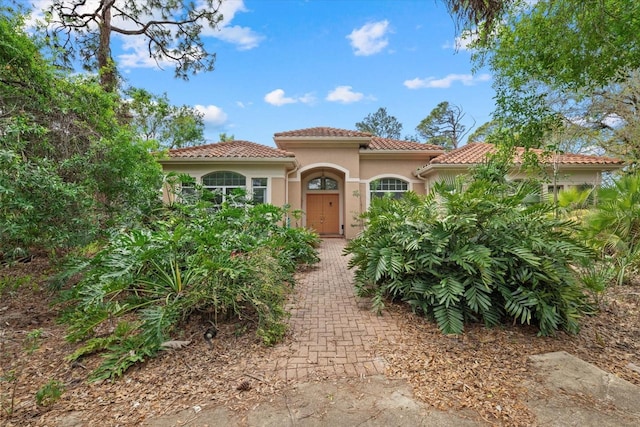 mediterranean / spanish-style house with a tiled roof and stucco siding