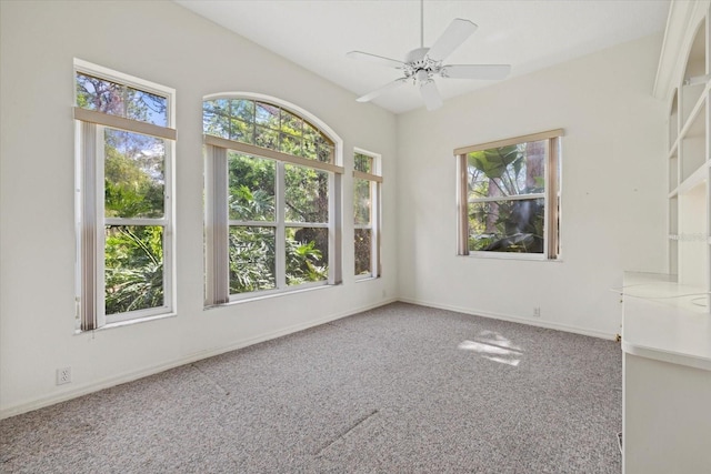 carpeted empty room featuring ceiling fan and baseboards