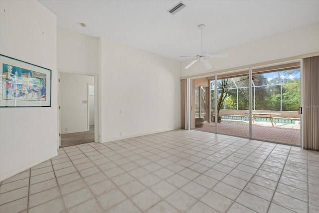 spare room featuring light tile patterned floors, baseboards, visible vents, a ceiling fan, and high vaulted ceiling