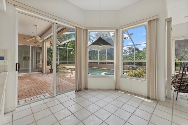 unfurnished sunroom featuring ceiling fan and a wealth of natural light