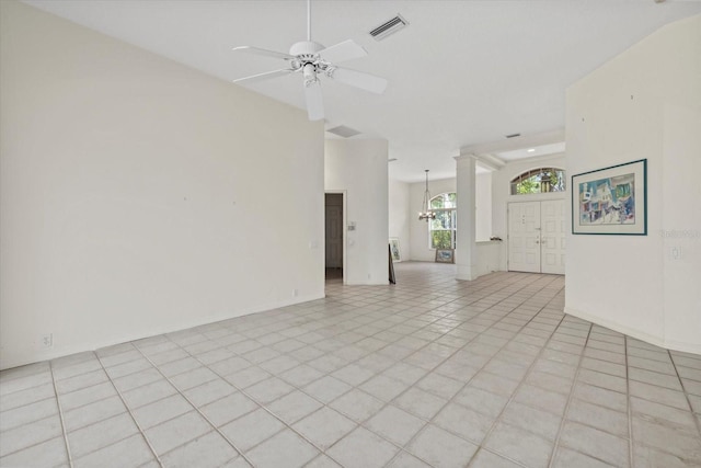 unfurnished room with light tile patterned floors, decorative columns, visible vents, and ceiling fan with notable chandelier