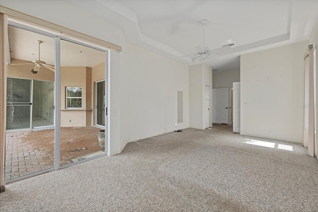 unfurnished bedroom featuring carpet floors, a raised ceiling, a towering ceiling, and a ceiling fan