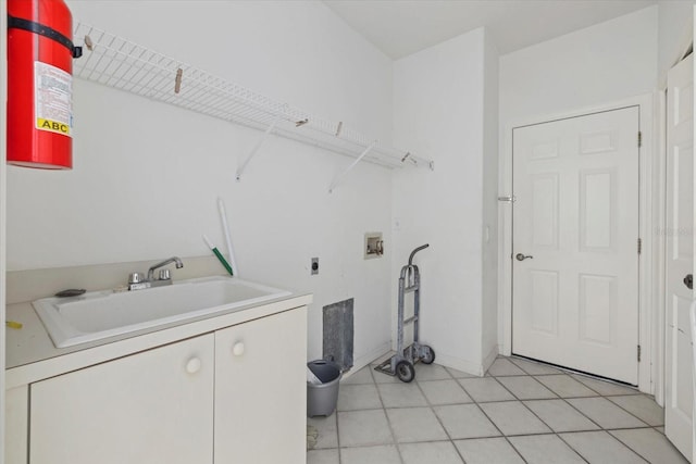 laundry area featuring light tile patterned floors, laundry area, washer hookup, a sink, and electric dryer hookup