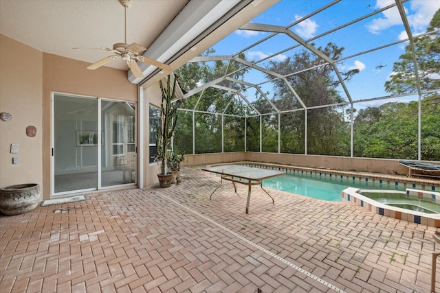 view of pool with a patio area, a pool with connected hot tub, glass enclosure, and a ceiling fan