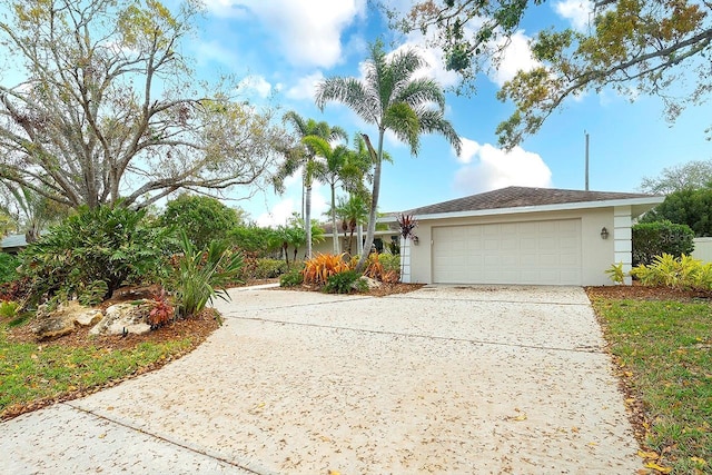 view of front of property with driveway, an attached garage, and stucco siding