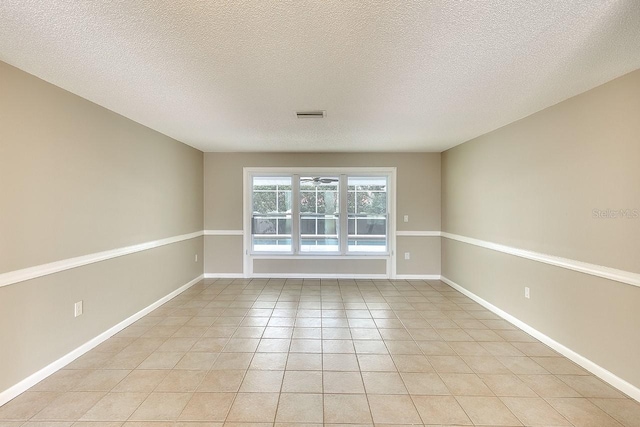 unfurnished room featuring light tile patterned floors, baseboards, visible vents, and a textured ceiling