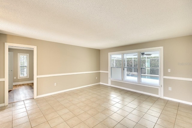 unfurnished room with a healthy amount of sunlight, baseboards, and light tile patterned flooring