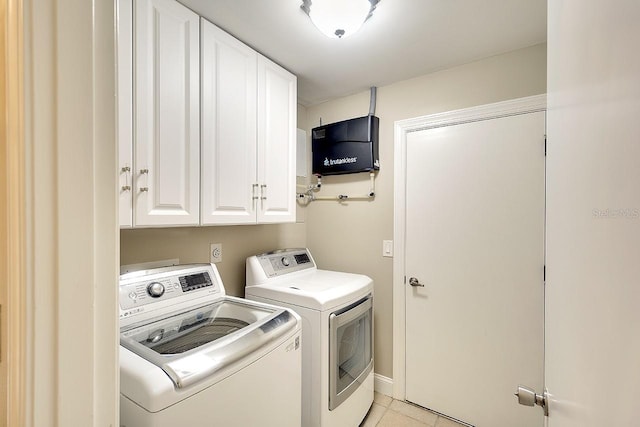 washroom with light tile patterned floors, cabinet space, and separate washer and dryer