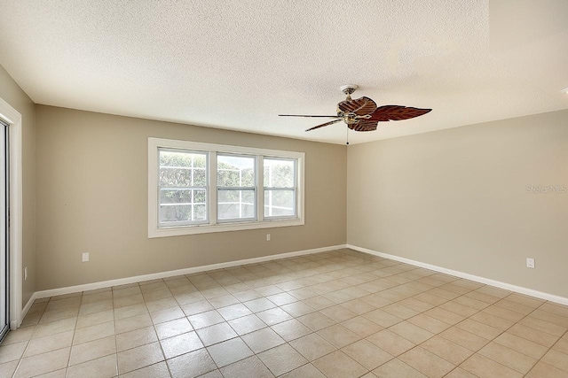 unfurnished room featuring a textured ceiling, light tile patterned flooring, a ceiling fan, and baseboards