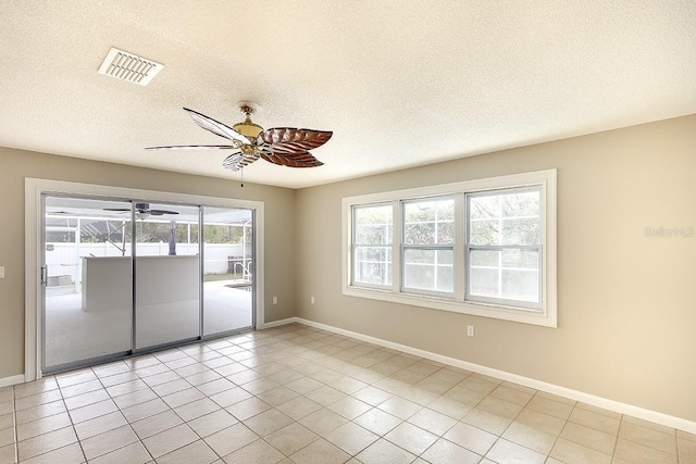 unfurnished room with a textured ceiling, visible vents, and baseboards