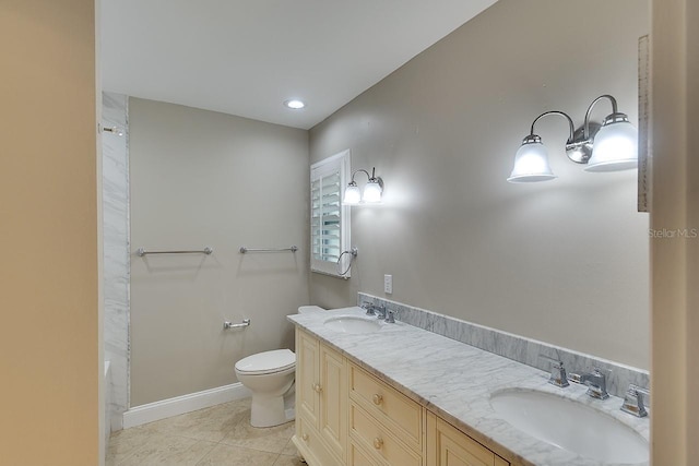 bathroom featuring toilet, double vanity, a sink, and tile patterned floors