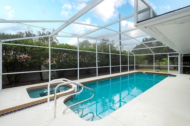 outdoor pool featuring glass enclosure, a patio, and an in ground hot tub