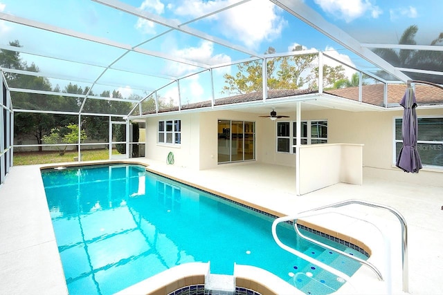 view of pool with a patio area, a pool with connected hot tub, glass enclosure, and a ceiling fan