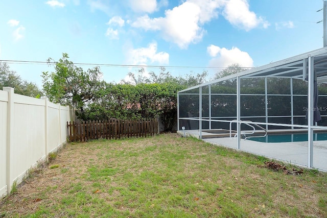 view of yard featuring a fenced in pool, a lanai, a fenced backyard, and a patio