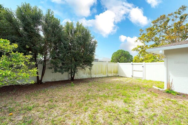 view of yard with a gate and a fenced backyard