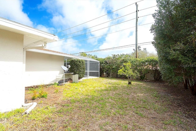 view of yard featuring glass enclosure and fence