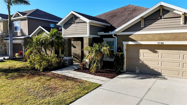 view of front of home featuring a garage, a shingled roof, driveway, stucco siding, and a front yard