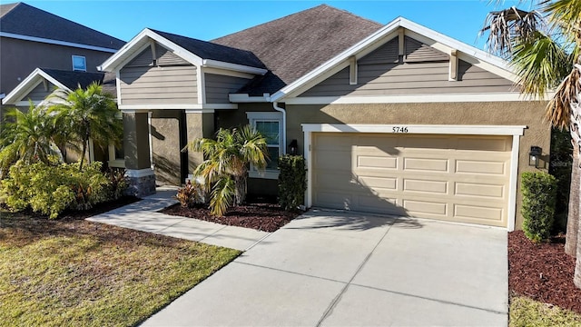 view of front facade with driveway, a shingled roof, an attached garage, and stucco siding