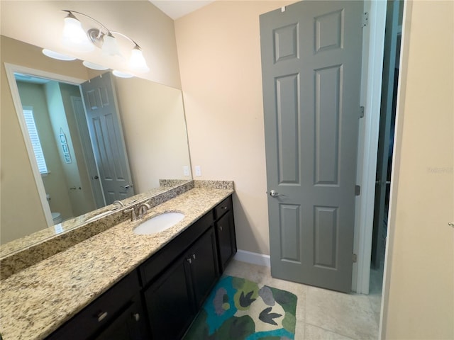 bathroom with toilet, tile patterned flooring, vanity, and baseboards