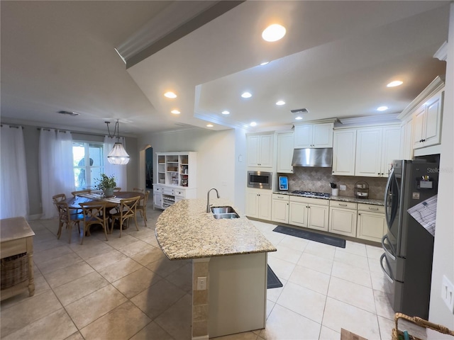 kitchen featuring light tile patterned floors, under cabinet range hood, a sink, appliances with stainless steel finishes, and backsplash