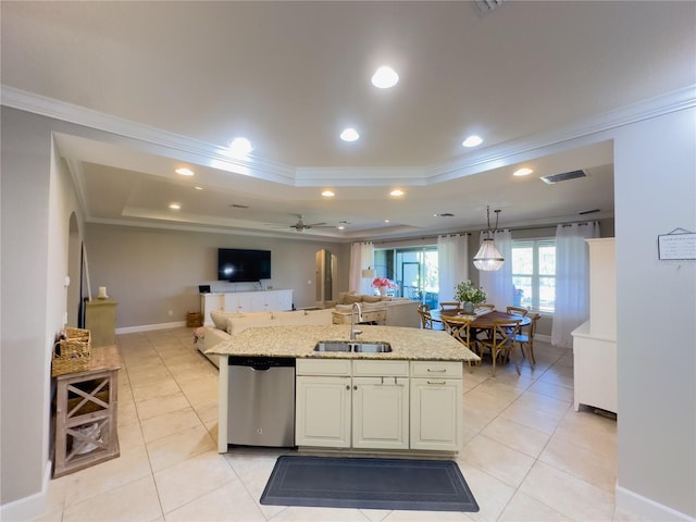 kitchen featuring arched walkways, open floor plan, a tray ceiling, stainless steel dishwasher, and a sink