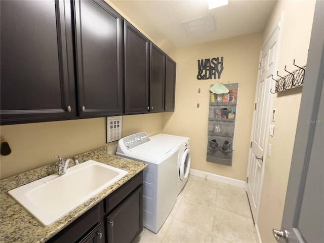 washroom with light tile patterned floors, cabinet space, a sink, independent washer and dryer, and baseboards