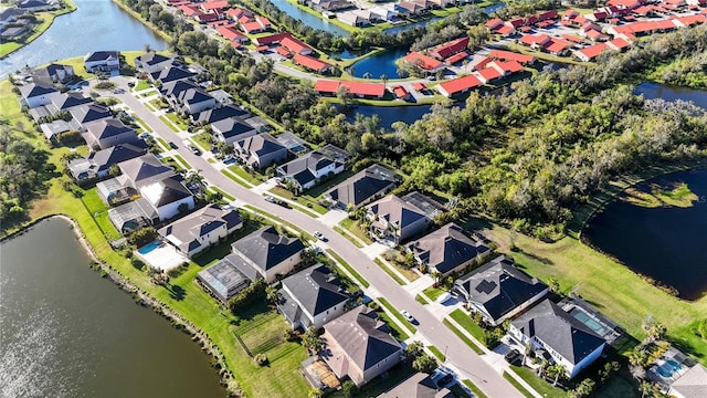 drone / aerial view with a residential view and a water view