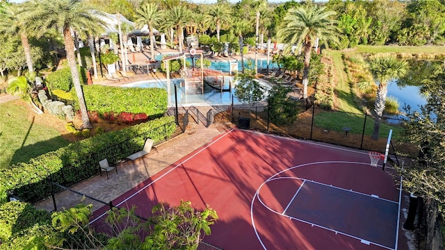 view of basketball court featuring a water view, community basketball court, and fence