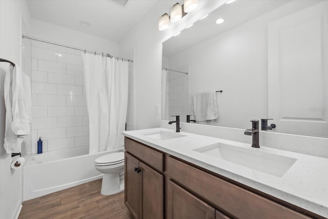 full bath with wood finished floors, shower / bath combo, a sink, and toilet