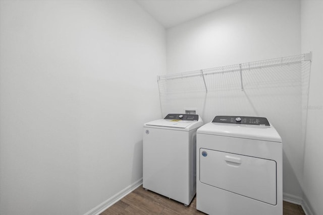 washroom with laundry area, baseboards, wood finished floors, and independent washer and dryer