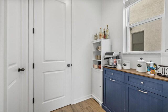 bar featuring baseboards and light wood-style flooring