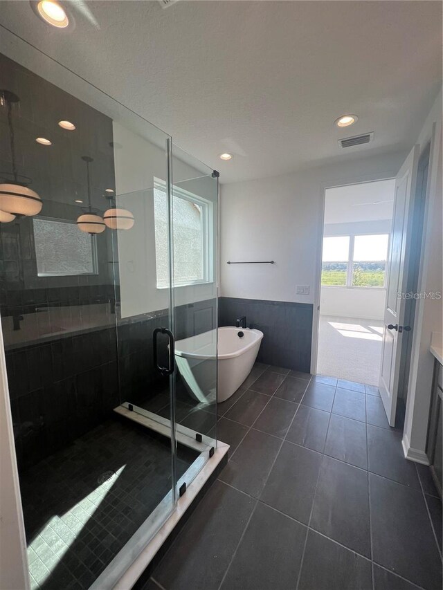 bathroom with tile patterned flooring, recessed lighting, a freestanding tub, a shower stall, and visible vents